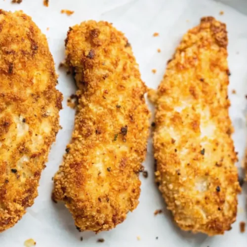 Goldbraune, knusprige Air Fryer Hähnchenstreifen serviert auf einem Teller mit einem BBQ-Dip.