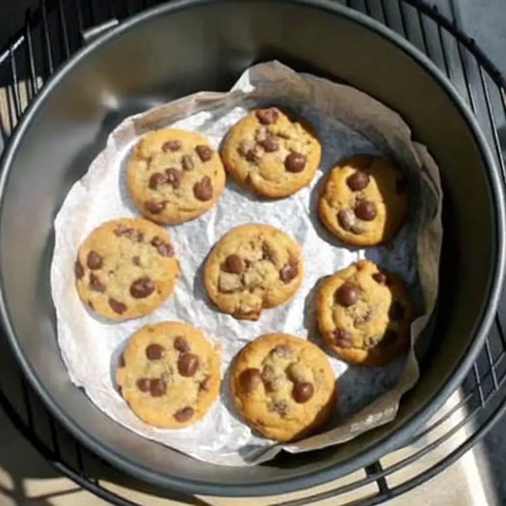 Cookies im Airfryer gebacken, goldbraune Chocolate Chip Cookies auf Backpapier im Fritteusen-Korb