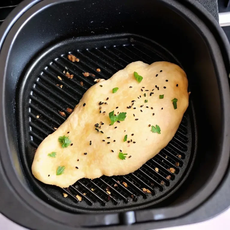 Naan Brot aus dem Airfryer: Flaches indisches Brot mit Sesam und Kräutern auf Grillrost im schwarzen Airfryer-Korb
